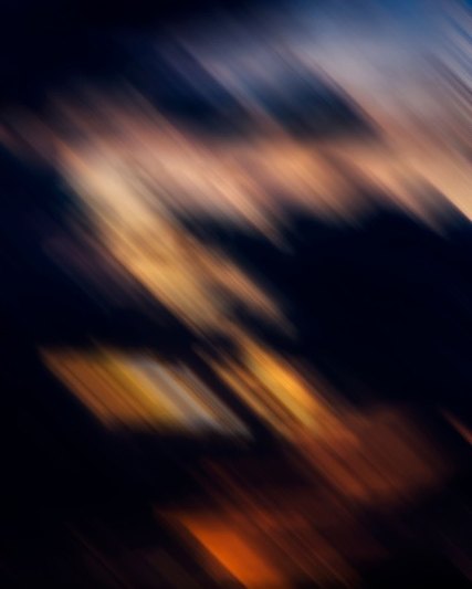 Diagonal streaks of navy, peach and orange light, blurred by motion