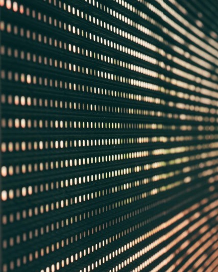 Close-up of a display wall of small warm lights in rows, like a stream of data
