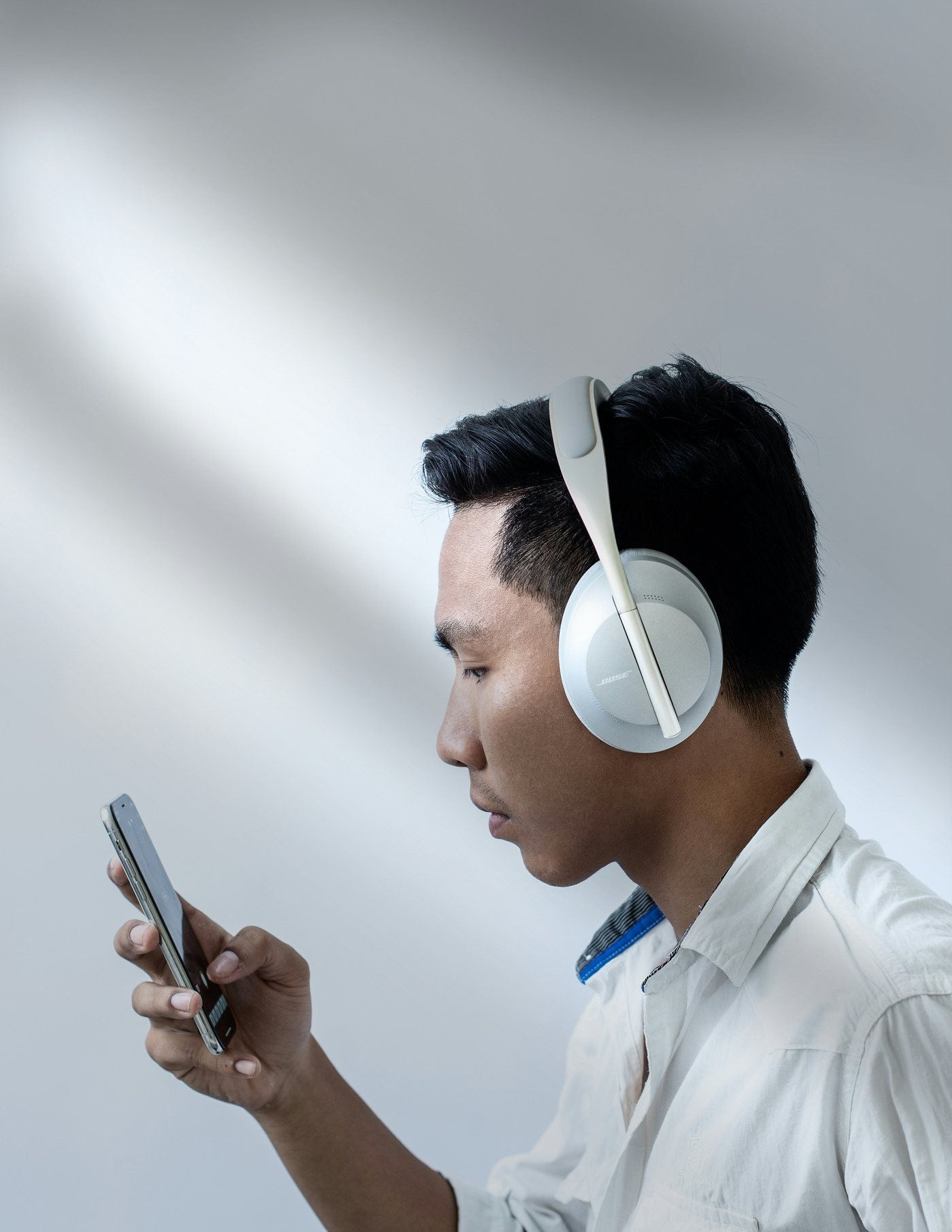A man with headphones checking his phone